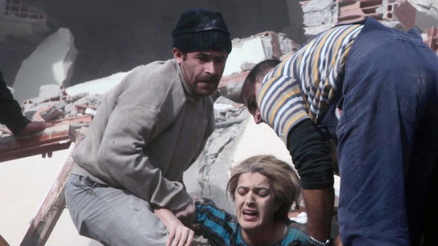 Two men help free a woman trapped under rubble after the earthquake in Turkey’s Van province.