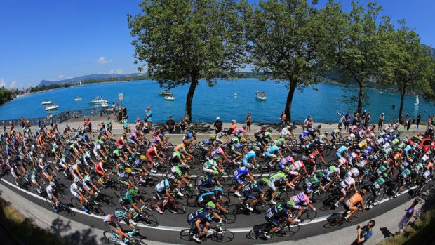 Tour de France cyclists pass Lake Annecy.