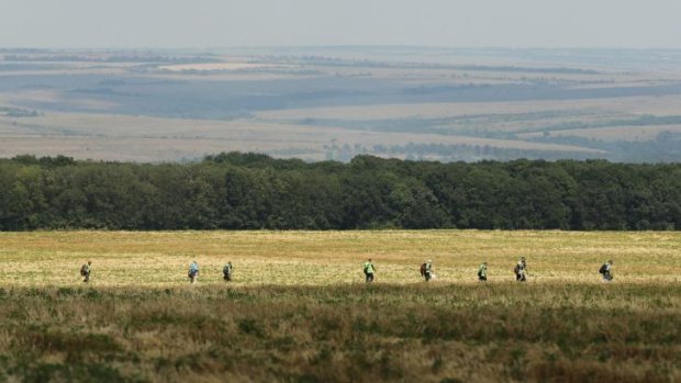 Australian Federal Police and their Dutch counterparts search a field for MH17 victims and belongings on the outskirts of Rassypnoye.