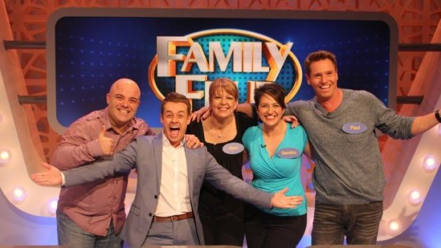 Host Grant Denyer (arms outstretched) with a family that won $16,000 and a car on Family Feud, the most culturally diverse program on television.
