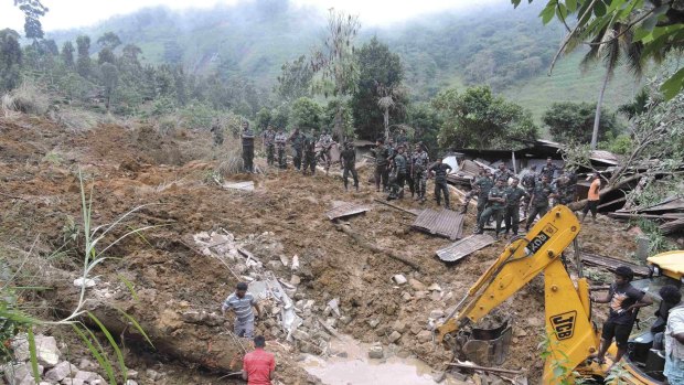 Difficult conditions: Rescue teams look for survivors of the landslide.