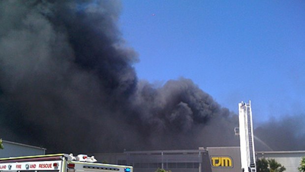 Plumes of black smoke rise into the air over the factory.