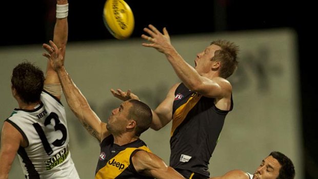 Jumping Jack: Tiger Jack Riewoldt leaps over teammate Brad Miller and Port's Cameron O'Shea (No. 13).