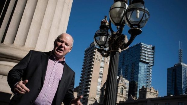 Quick fix?: Gerard Vaughan on the Parliament steps with the city's changing city skyline rising in the background.