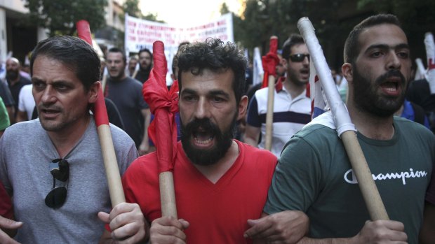 Anti-Euro protesters march through the streets during an anti-austerity rally in Athens, as Prime Minister Alexis Tsipras battled to win lawmakers' approval on Wednesday for a bailout deal.