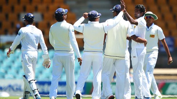 United: The Sri Lanka team celebrates the fall of a wicket during the tour opener against the Chairman's XI in Canberra.