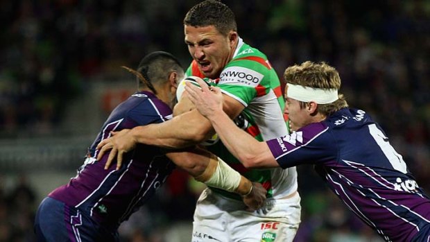 Sam Burgess of the Rabbitohs is tackled by Brett Finch of the Storm during the round 22 match on Friday.