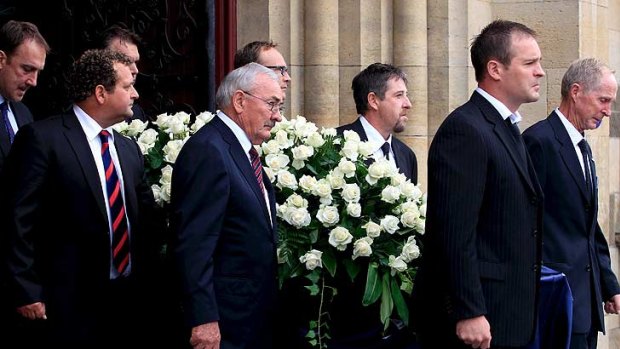 Jim Stynes' casket is carried from the service by pall bearers.