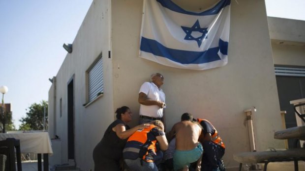 Israelis take cover as a siren warning of incoming rockets sounds in the southern city of Ashkelon.