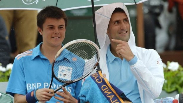 Novak Djokovic (R) shares a joke with a ball boy.