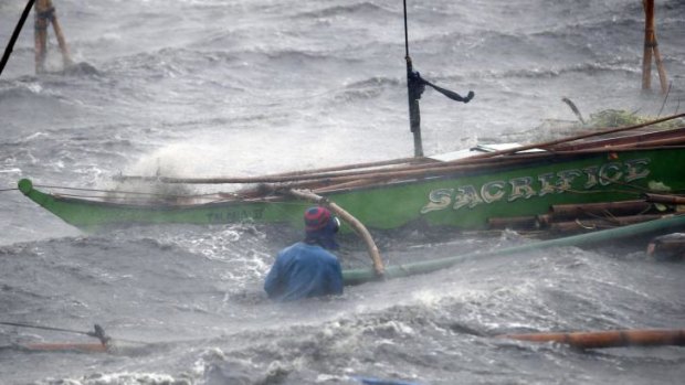 A fisherman tries to secure his boat at Imus.