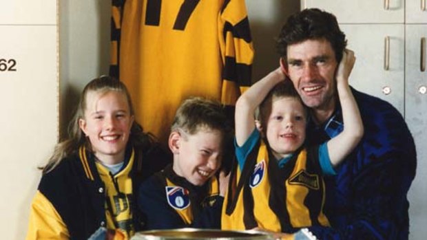 Hawthorn legend Michael Tuck with his children, Renee, Shane and Travis, on his knee, in 1991.