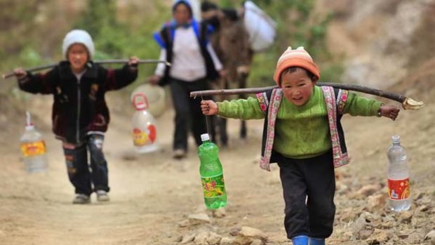 Two boys carry bottles of water during a severe drought in Kunming, southwest China's Yunnan province.