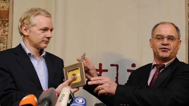 WikiLeaks founder Julian Assange, left, receives CDs from former banker Rudolf Elmer.