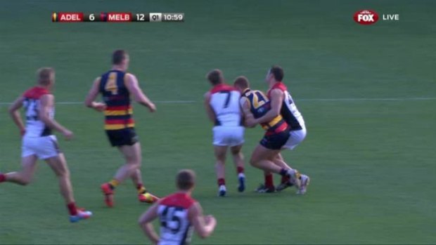 Adelaide's Tom Lynch had his jaw broken in this clash with Melbourne's Jack Viney (left) and Alex Georgiou. 