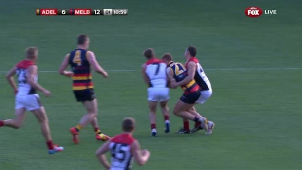 Adelaide's Tom Lynch had his jaw broken in this clash with Melbourne's Jack Viney (left) and Alex Georgiou. 