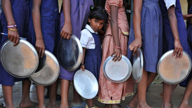 Schoolchildren queue for a midday meal as Prime Minister Manmohan Singh labels child malnutrition a national shame.