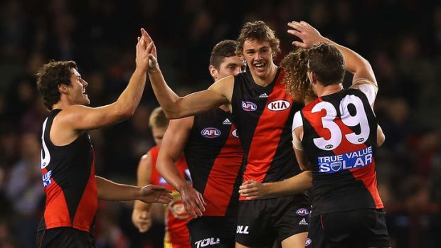 Joe Daniher is congratulated by team mates after kicking a goal.