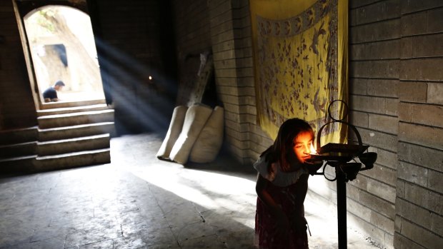 A displaced Yazidi girl worships at   Lalish temple in Shikhan last year.