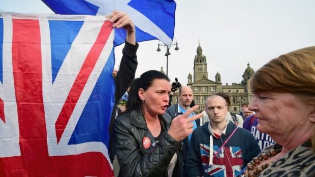 Heated debate ... A yes supporter talks with a man and a woman with a Union flag in George Square in Glasgow, Scotland.