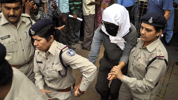 Traumatising: A Swiss woman is escorted by police for a medical examination at a hospital in Gwalior.