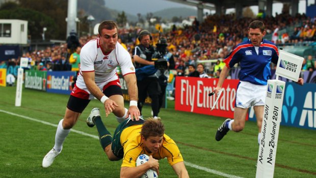 Flat out: Drew Mitchell scores a try against Russia before succumbing to a hamstring injury.