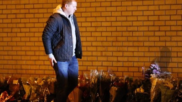Celtic manager Neil Lennon leaves flowers near the scene of a helicopter crash in central Glasgow.