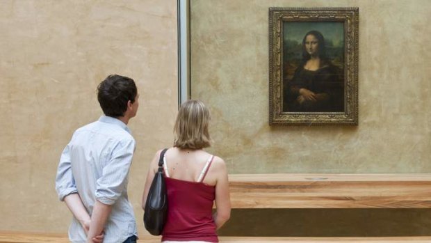 Visitors to the Louvre admire the <i>Mona Lisa</i> by Leonardo da Vinci.