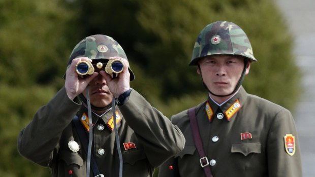 A North Korean soldier looks at the southern side through binoculars. 