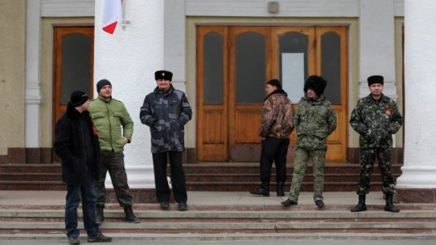 Pro-Russian “self-defence” forces and Cossacks  in front of a building that joins the control tower at Simferopol airport.