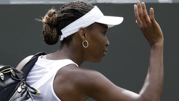 Bye for now: Venus Williams waves to fans after being knocked out of Wimbledon by Russia's Elena Vesnina.