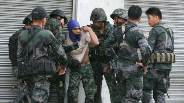 Violence: Soldiers check a comrade who was hit by a sniper following a clash between a  Philippine navy patrol and suspected Moro Islamic Liberation Front rebels  in Zamboanga