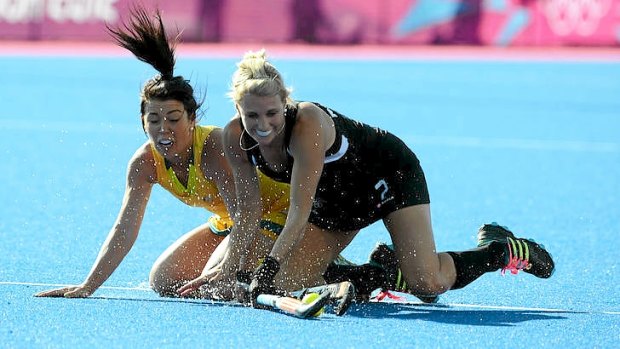 New Zealand's Emily Naylor battles with Australia's Jade Close in their Olympic hockey pool match.