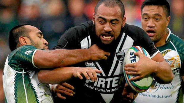 Sam Kasiano of New Zealand is tackled by Zeb Taia (L) and Tinirau Arona of the Cook Islands.