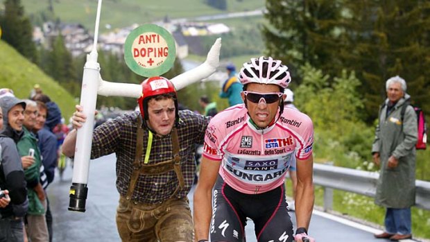 Pointed approach: Alberto Contador is followed by a fan brandishing a giant syringe during the 15th stage of the Giro d'Italia.