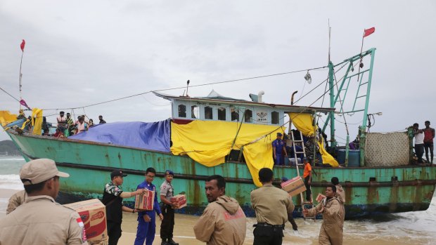 Indonesian officials load food supplies onto a boat carrying Tamil migrants which have been stranded on the beach in Lhoknga, Aceh province, Indonesia. Indonesia has allowed a group of Tamil migrants from Sri Lanka to come ashore in Aceh province after confining them to their stranded boat for a week. 