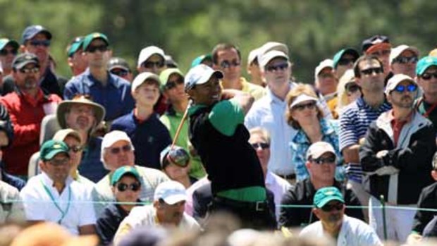 Relaxed ... Tiger Woods, and a packed gallery, watch the progress of his tee shot on the eighth hole during the second day of the Masters tournament.