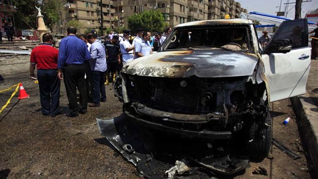 Bomb attack: Security personnel gather at a site of an explosion against the convoy of the Egyptian interior minister Mohammed Ibrahim.
