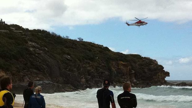 A rescue helicopter yesterday hovers over the area where the plane went down at North Curl Curl.