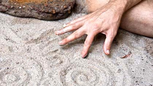 Ancient ways ... Evan Yanna Muru draws symbols in the sand.