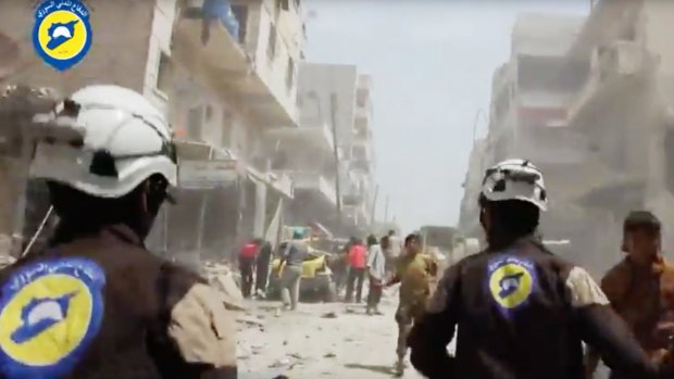 Syrian Civil Defence White Helmets workers run after airstrikes and shelling hit Aleppo.