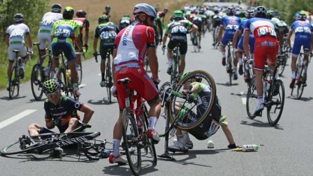 Tumbling down: defending champion Chris Froome (L) hits the bitumen.