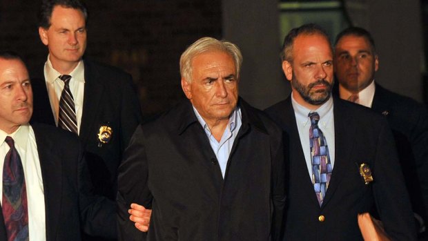 IMF head Dominique Strauss-Kahn is taken out of a police station in New York.