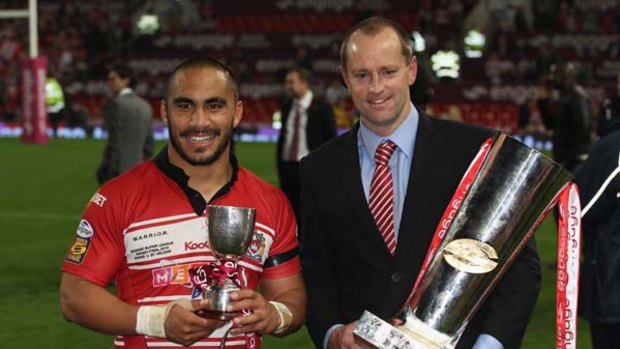 Michael Maguire of the Wigan Warriors lifts the 2010 Super League Grand Final trophy next to man of the match Thomas Leuluai.