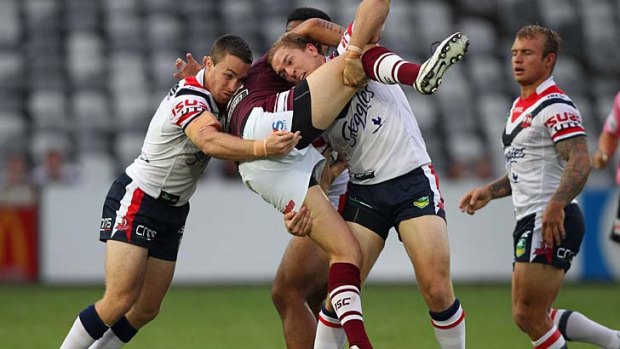 Justin Horo of the Sea Eagles is dumped by the Roosters defence.
