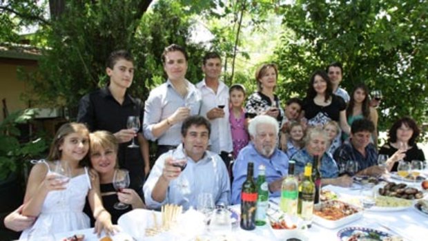 Wine dynasty ... extortion victim John Casella, centre left, and his father, Filippo, at a family gathering near Griffith. Their business produces Yellow Tail wine.
