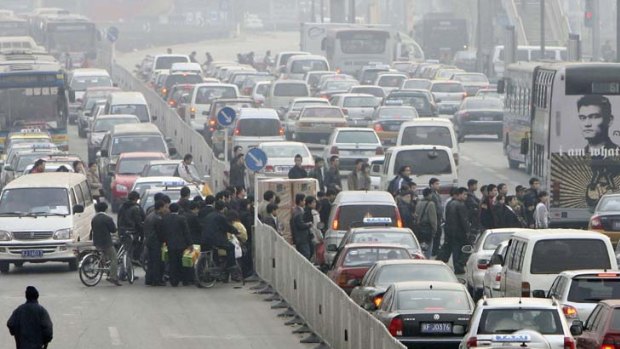 A tale of two eras ... a smog-filled, modern Beijing street is jammed with cars.