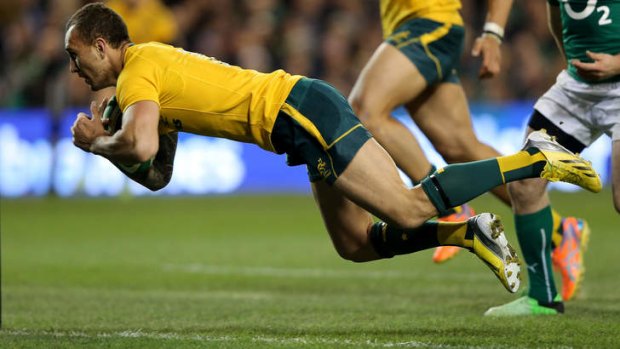 Bodies in motion: Quade Cooper finishes off an impressive attacking raid by the Wallabies.
