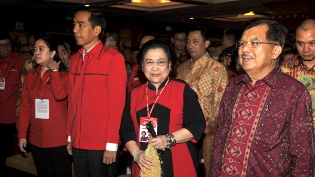 Joko Widodo, now shouldering the responsibilities of leading Indonesia, looking sombre as he stands next to a smiling Megawati Sukarnoputri, the former president of Indonesia, at the Indonesian Democratic Party of Struggle (PDIP) congress in Bali earlier this month.