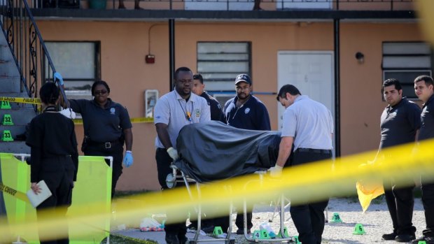A body is removed from the site of the latest mass shooting in the US. Two people are dead and seven injured after two men discharged automatic weapons into a crowd in Miami, Florida.